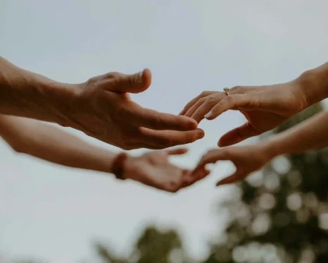 Photographie des mains de deux personnes se touchant