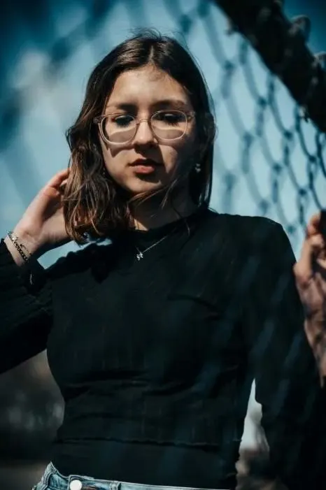 Portrait d'une femme devant un grillage